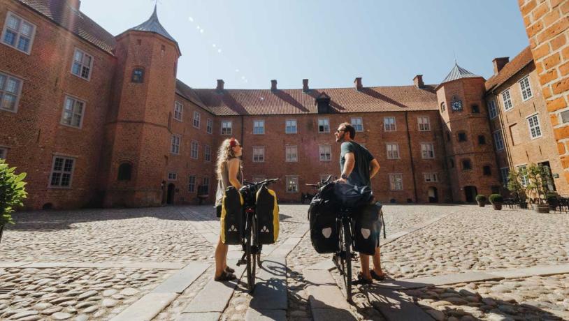 Paar mit Fahrrädern im Park am Schloss Sønderborg