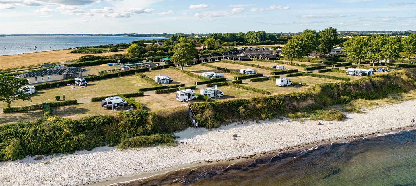 Dronefoto af Drejby Strand Camping med strand og vand på begge sider