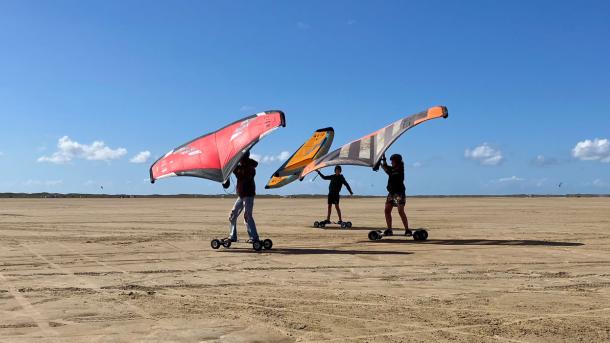 Tre personer kører med Kitewings på Sønderstrand, Rømø