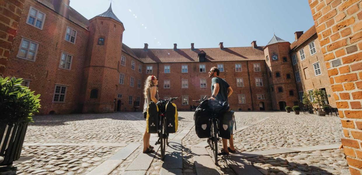 Paar mit Fahrrädern im Park am Schloss Sønderborg