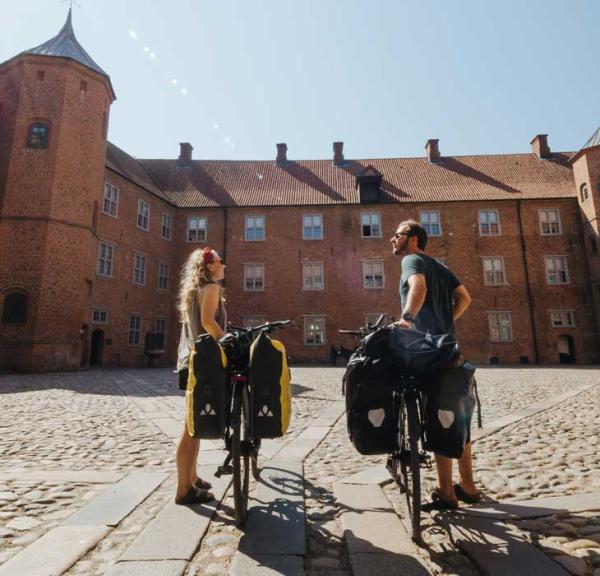 Paar mit Fahrrädern im Park am Schloss Sønderborg