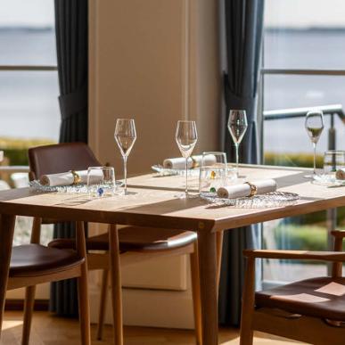 Veldækket bord med udsigt til havet ved Pearl by Paul Proffitt