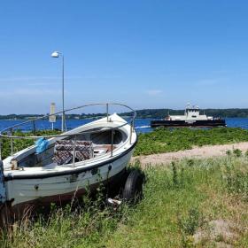 Barsø - Boot am Strand und Fähre im Hintergrund